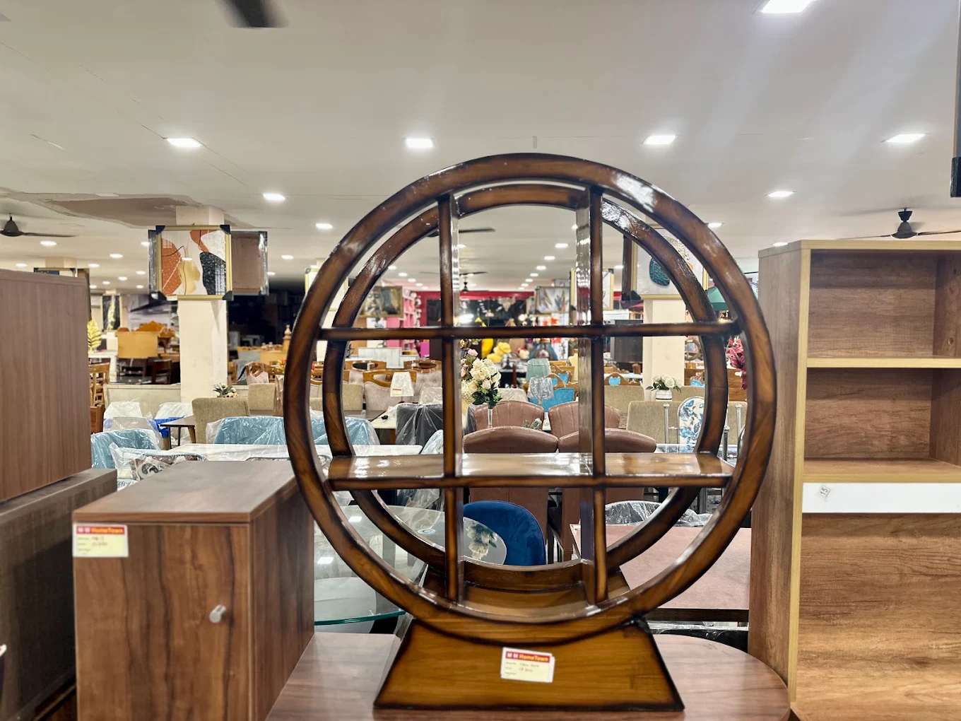 Circular wooden display unit with MM HomeTown tag